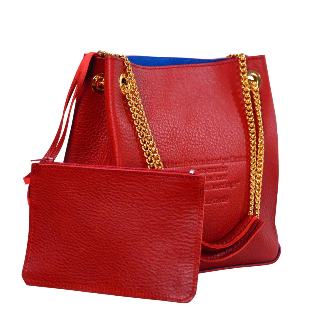 A red woman's handbag with gold chain handles, made from vegetable tanned leather, with leather pochette.